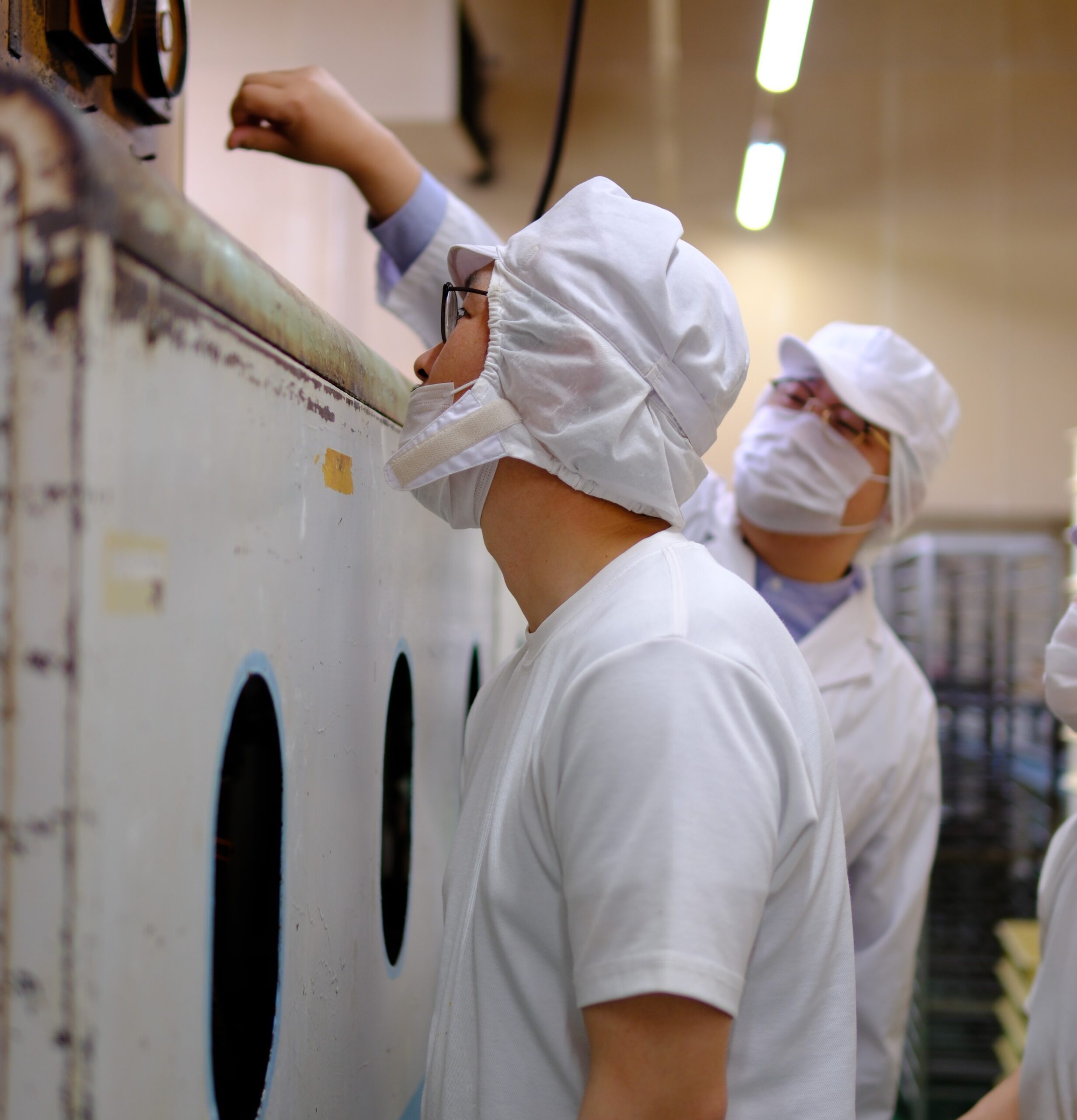 オーブンの上から内部を覗き込む職人